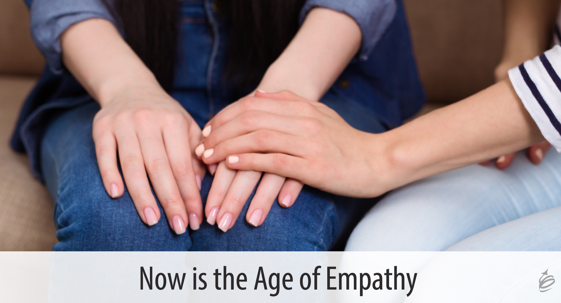  A close up of two people holding hands with the text "Now is the Age of Empathy."